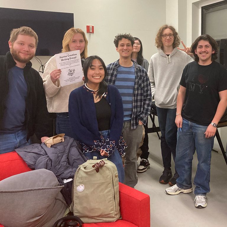 Students smile and post for photo in the arts student lounge.