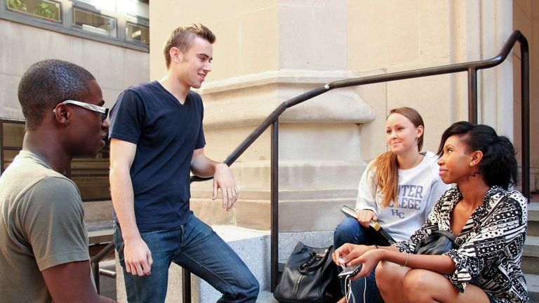 Students hanging out on steps outside a building