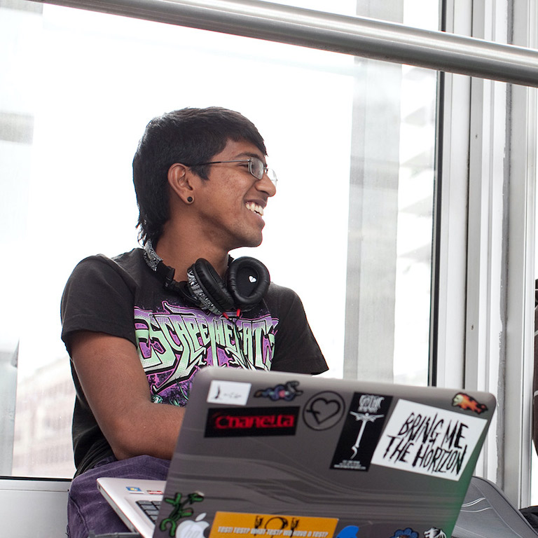 student with laptop on skybridge
