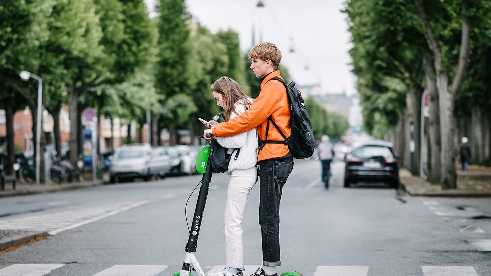 Two people riding a electric scooter