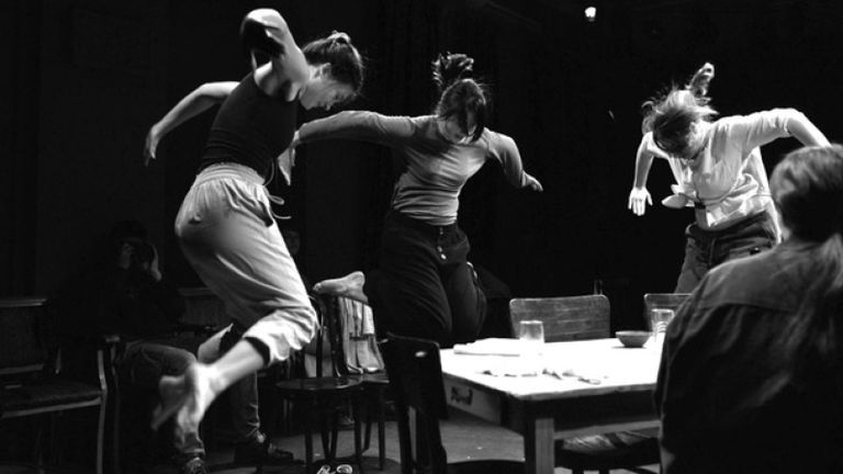 Black and white photo of actresses dancing on stage.