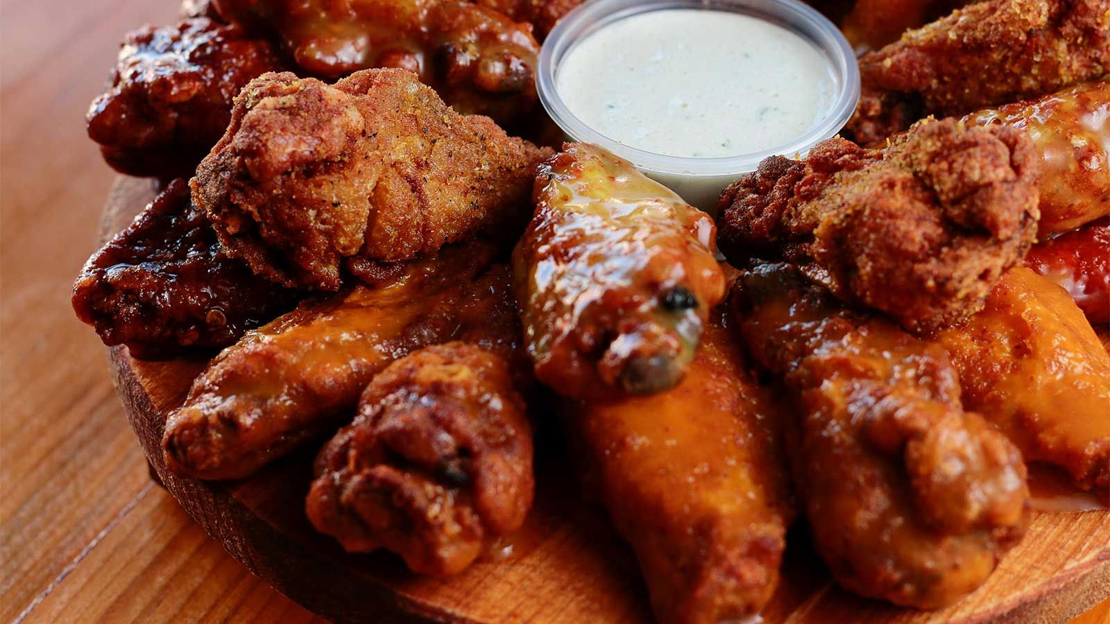plate of hot wings with dipping sauce