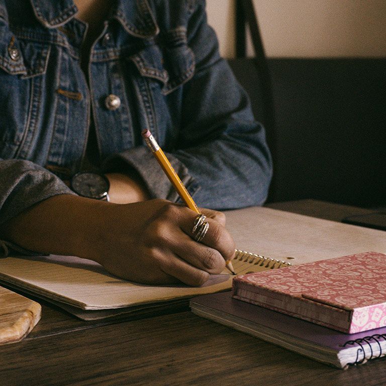 close-up of a person writing in a notebook